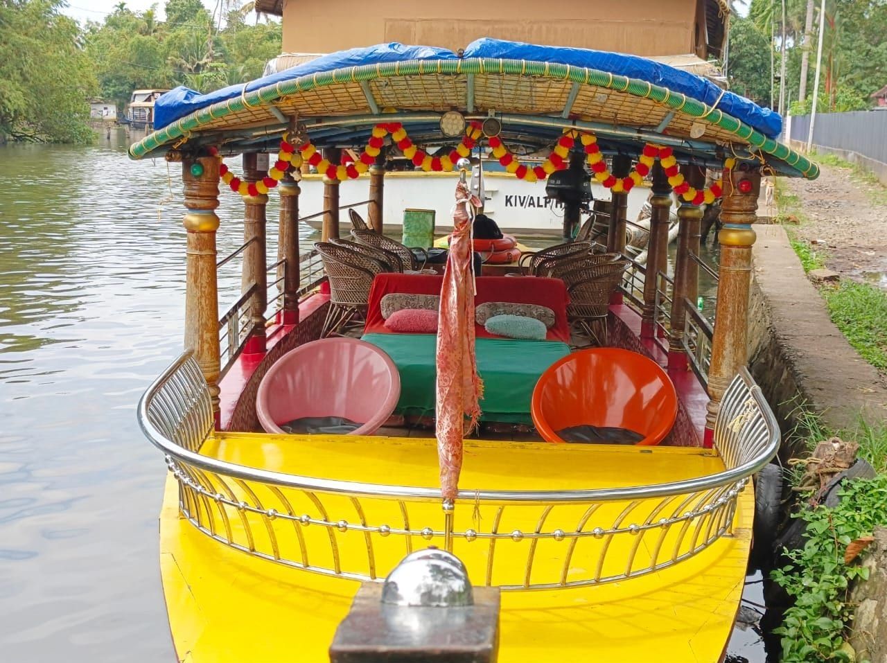 Yellow shikara decorated with marigold garlands and cane chairs