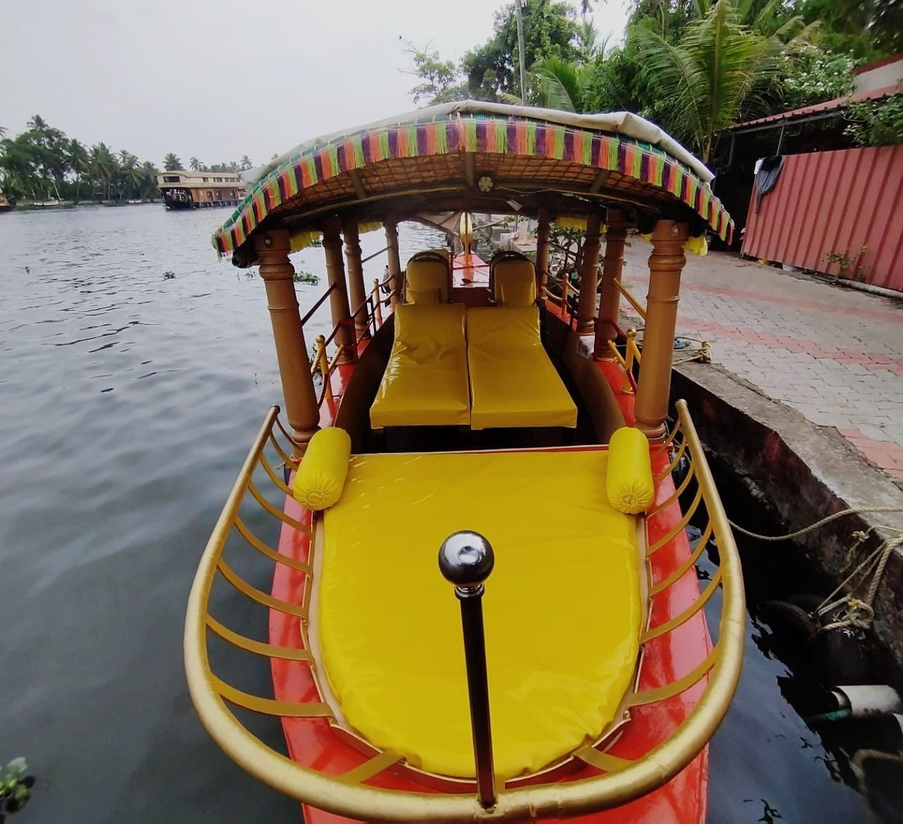 Front deck of a shikara with yellow cushions, ready for a backwater cruise