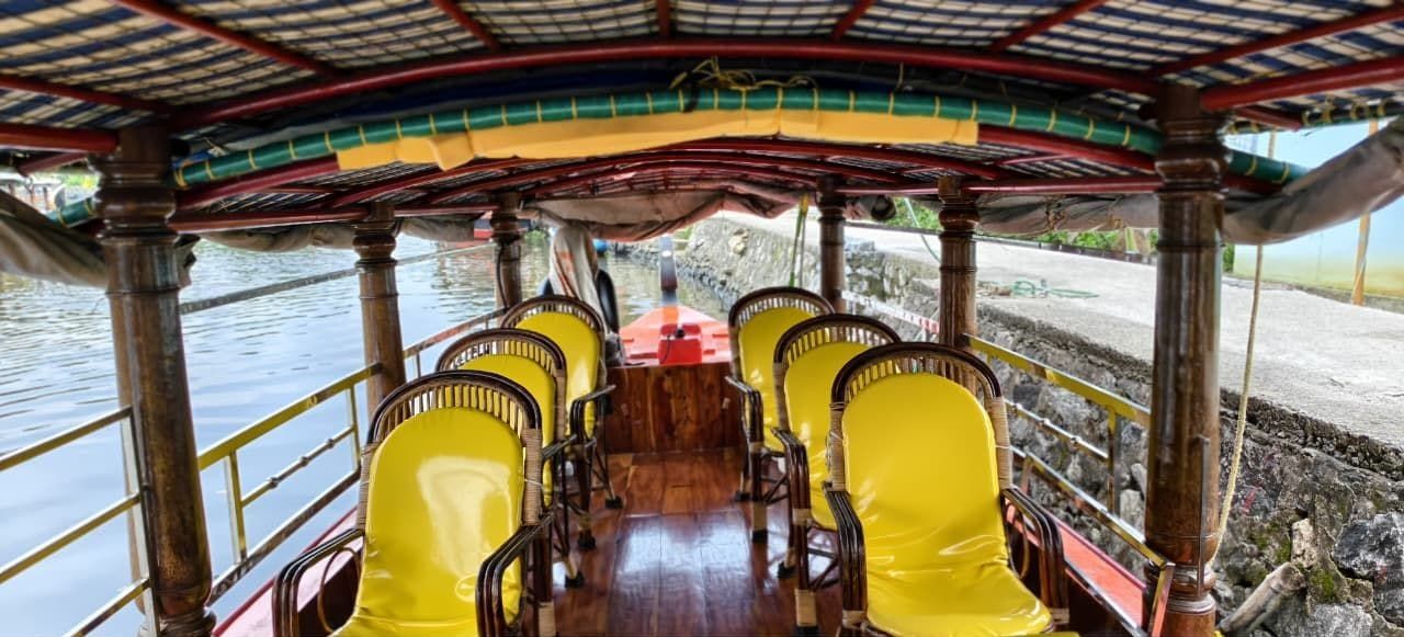 Shaded shikara interior with rows of cushioned seats and open views